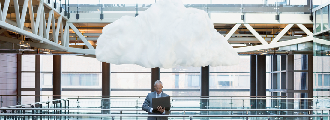 Man with laptop with cloud overhead